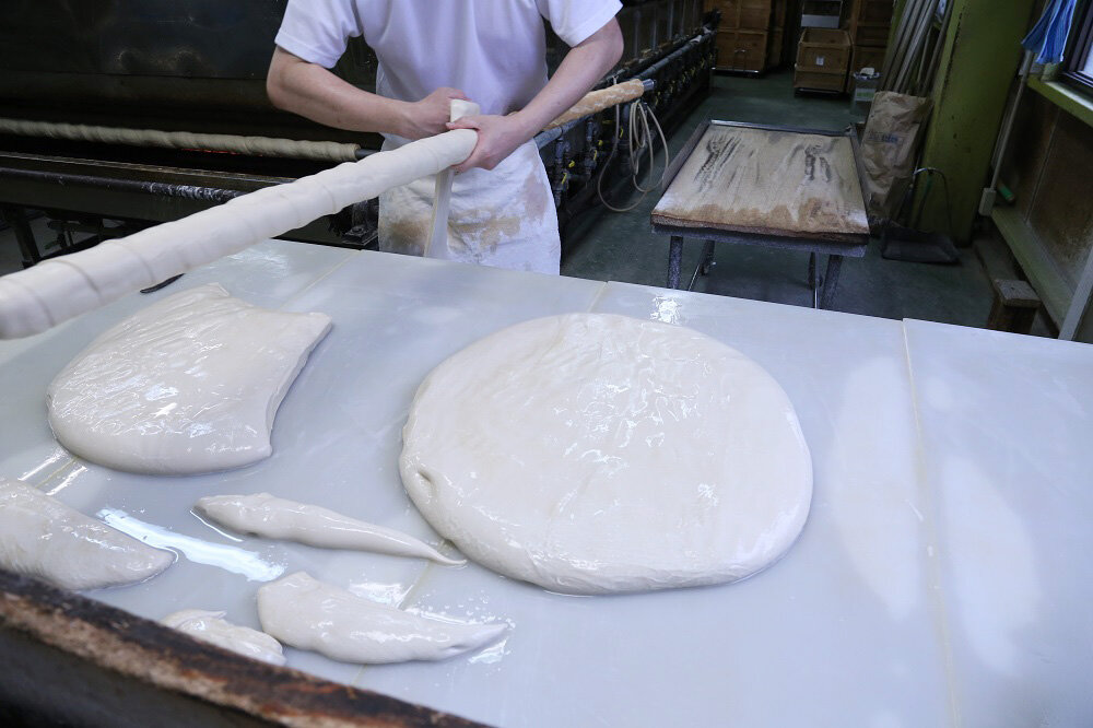 麩生地を長く伸ばし、棒に巻きつける