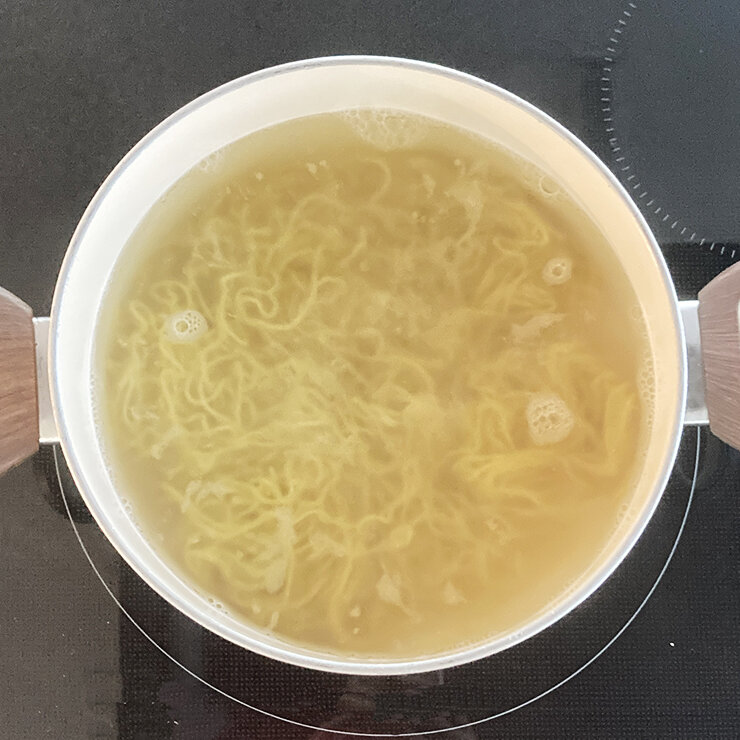中華麺はたっぷりの湯で茹でてザルにあげ、水でもみ洗いし水気を切ります。ゴマ油をからめます。
