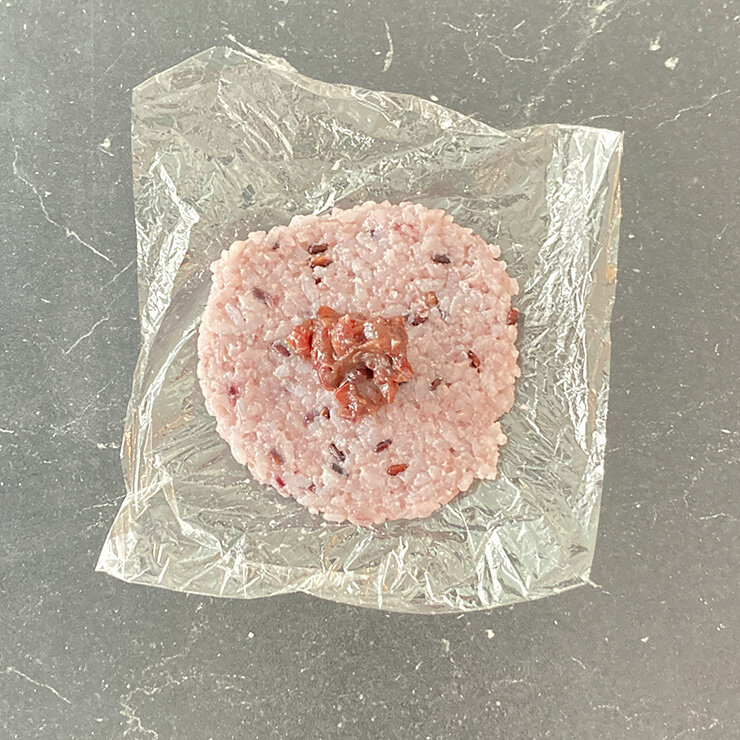 上からラップをのせて、10㎝程の円形に伸ばし、粒あんをのせます。
