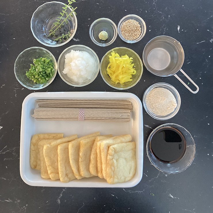 油揚げは長い辺を半分に切ります。