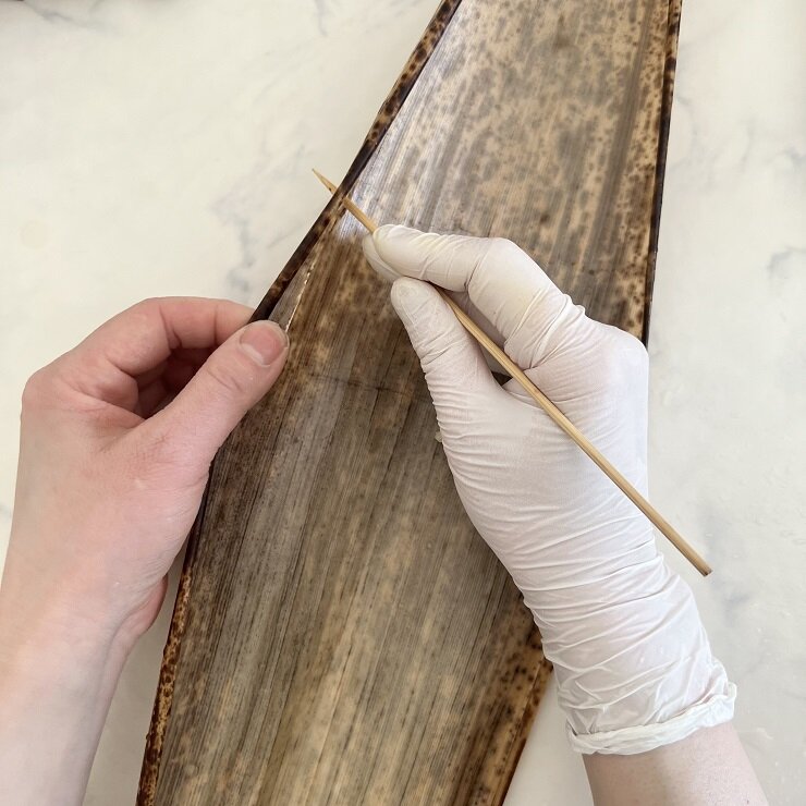 竹の皮の水気を拭いて、ひも用に端を細く切り取ります。