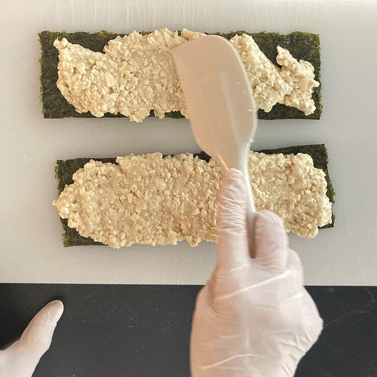4を4等分して焼き海苔の片面に広げて平らにし、形を整えます。