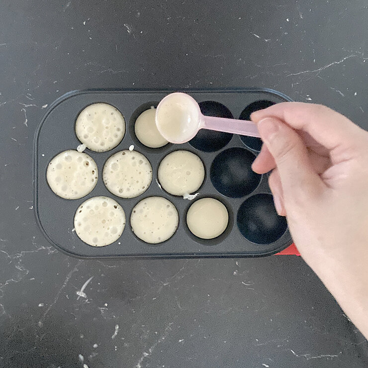 たこ焼き機を熱します。温まったらキッチンぺーパーなどで薄く油を塗ります。 生地を小さじ1杯弱流します。（穴の高さの半分くらいが目安です）。
