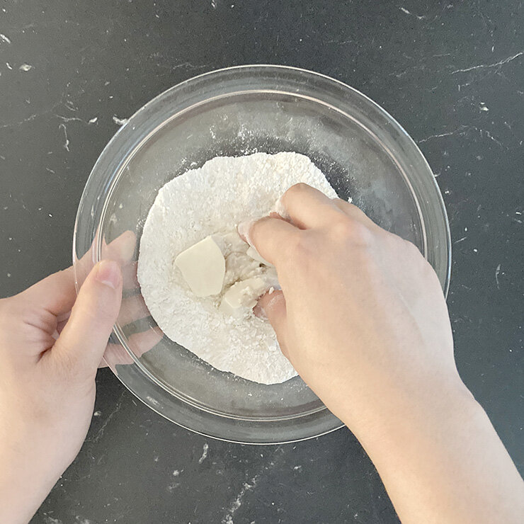 豆腐白玉を作ります。ボウルに白玉粉と砂糖を入れて混ぜ、絹ごし豆腐を加えてよく練ります。