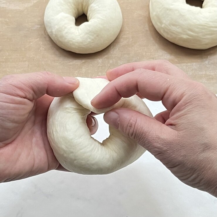 手前から丸めて閉じ、片方のを端を麺棒で伸ばし、輪を作りながらもう片方の端を包み込みます。